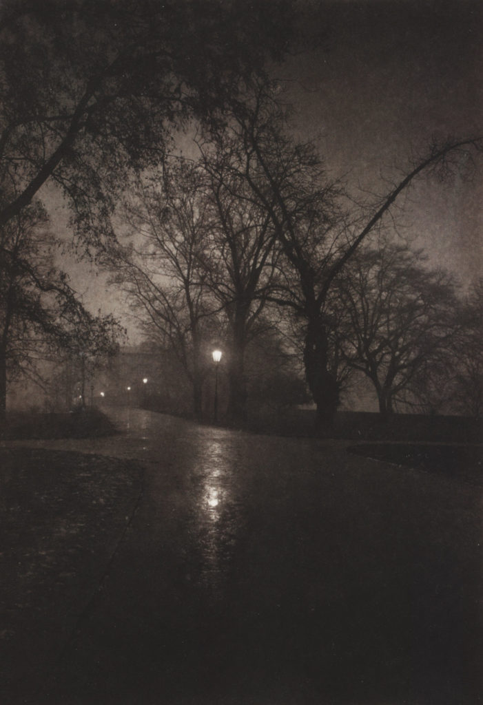 Photographie d'une allée dans un parc, la nuit.